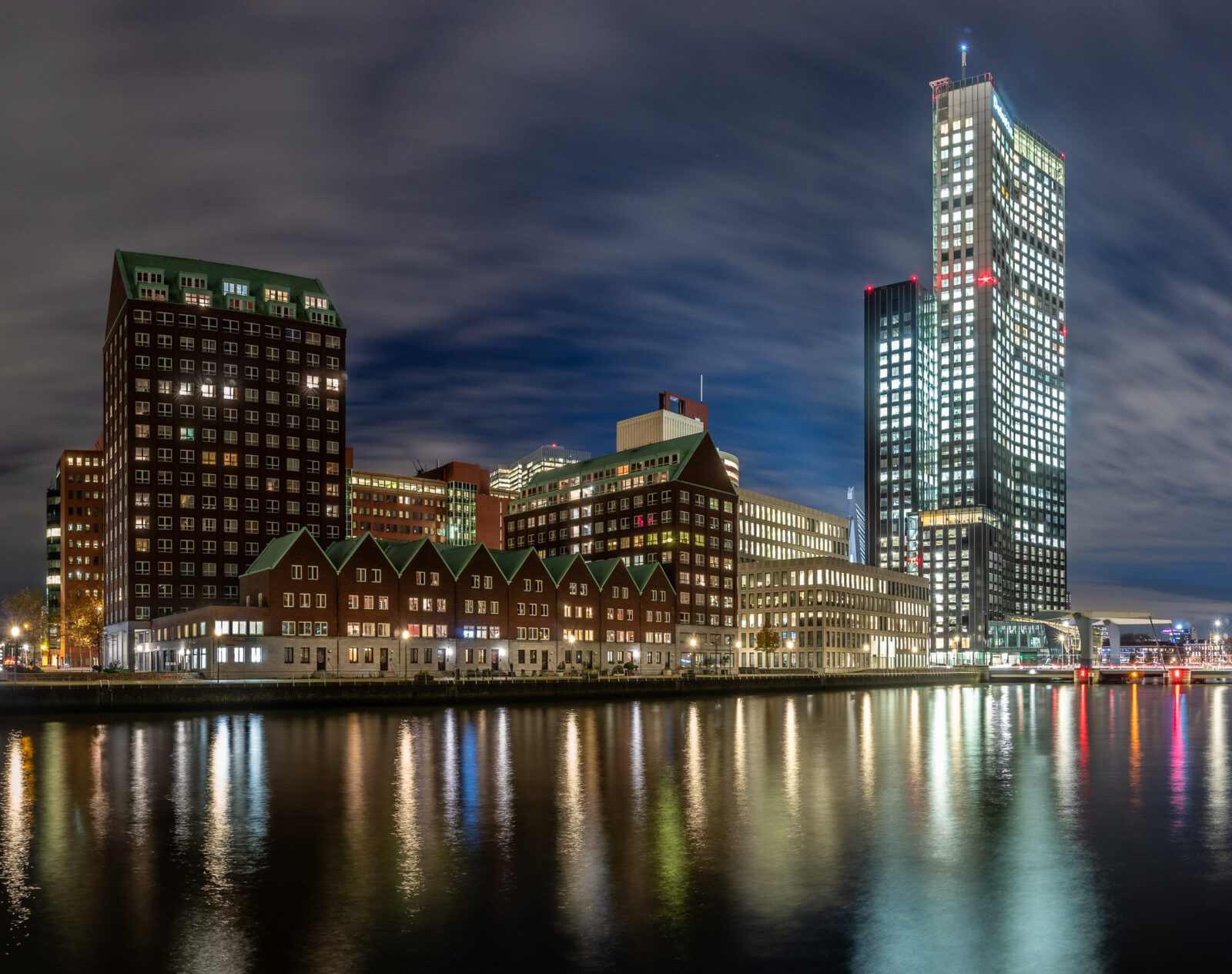 De verlichte stad weerspiegeld in het water, Rotterdam