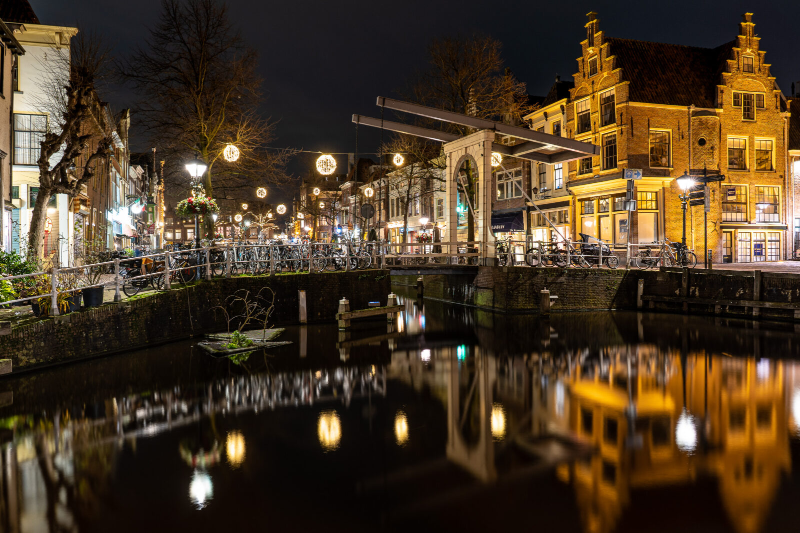 Verlichte gracht met brug bij nacht, Alkmaar