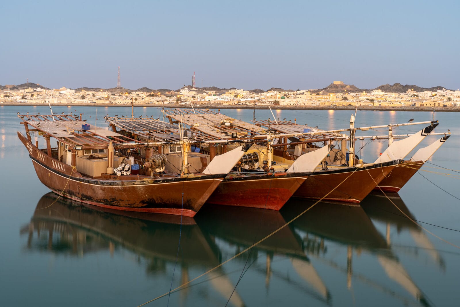 Dhows in rustig water bij zonsopkomst op Masirah