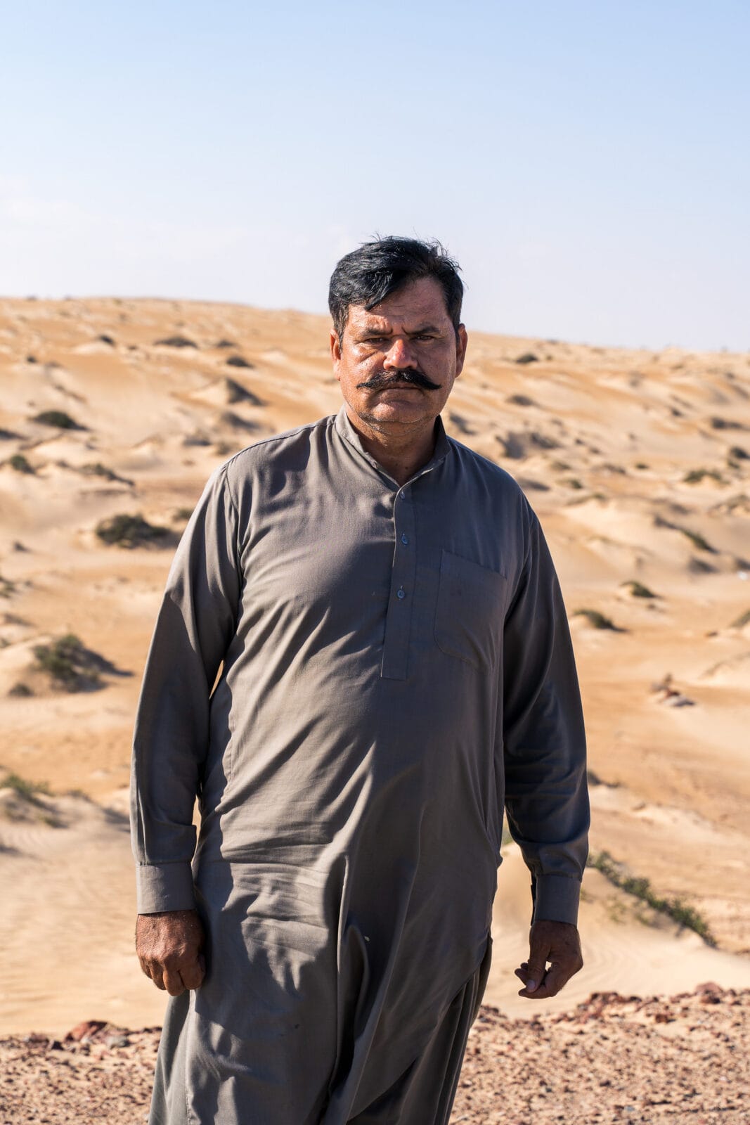 Man in het lege woestijnland bij Al Juwayrah