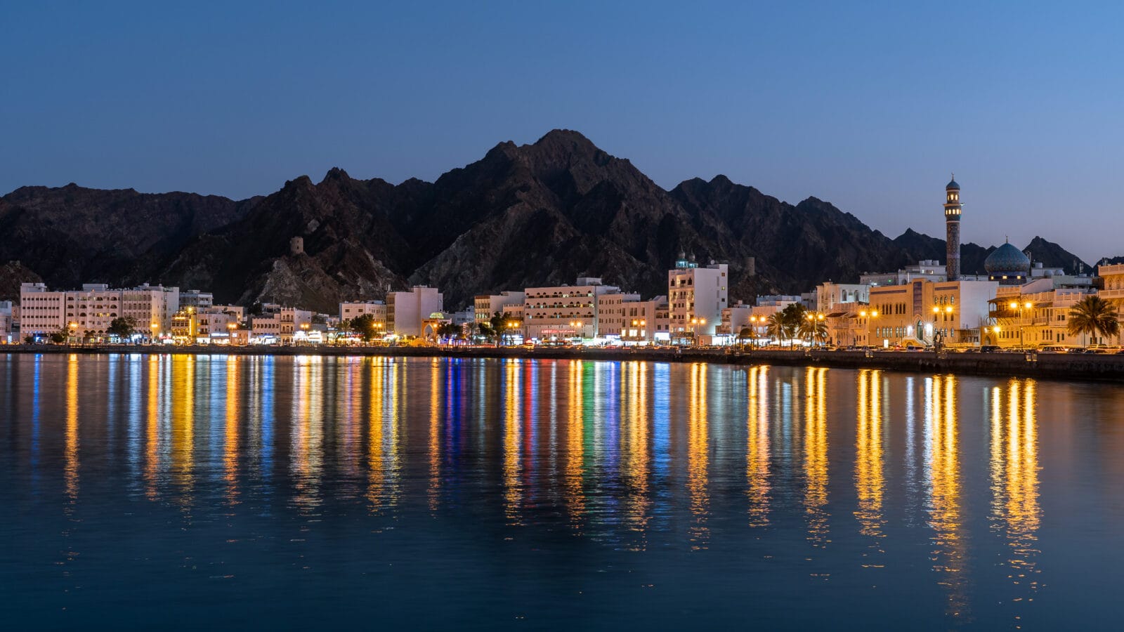 Stadslichten weerspiegeld in het water bij Muttrah, Muscat