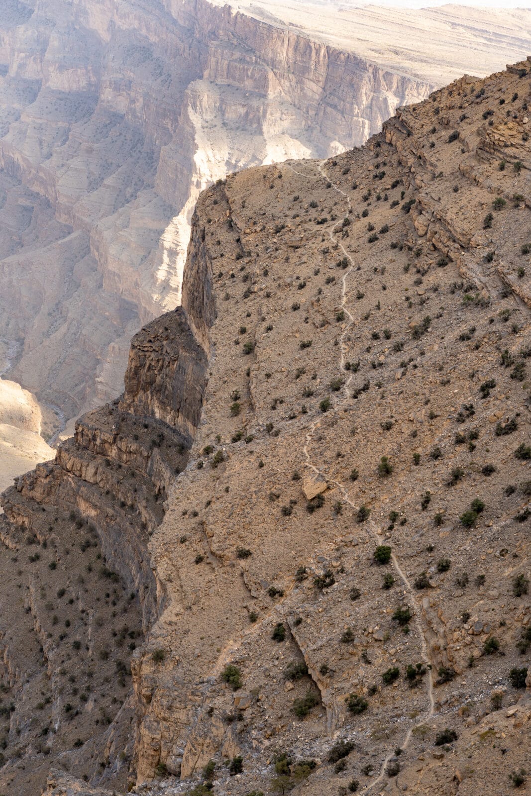 Pad klimt langs een steile berghelling bij Jebel Shams