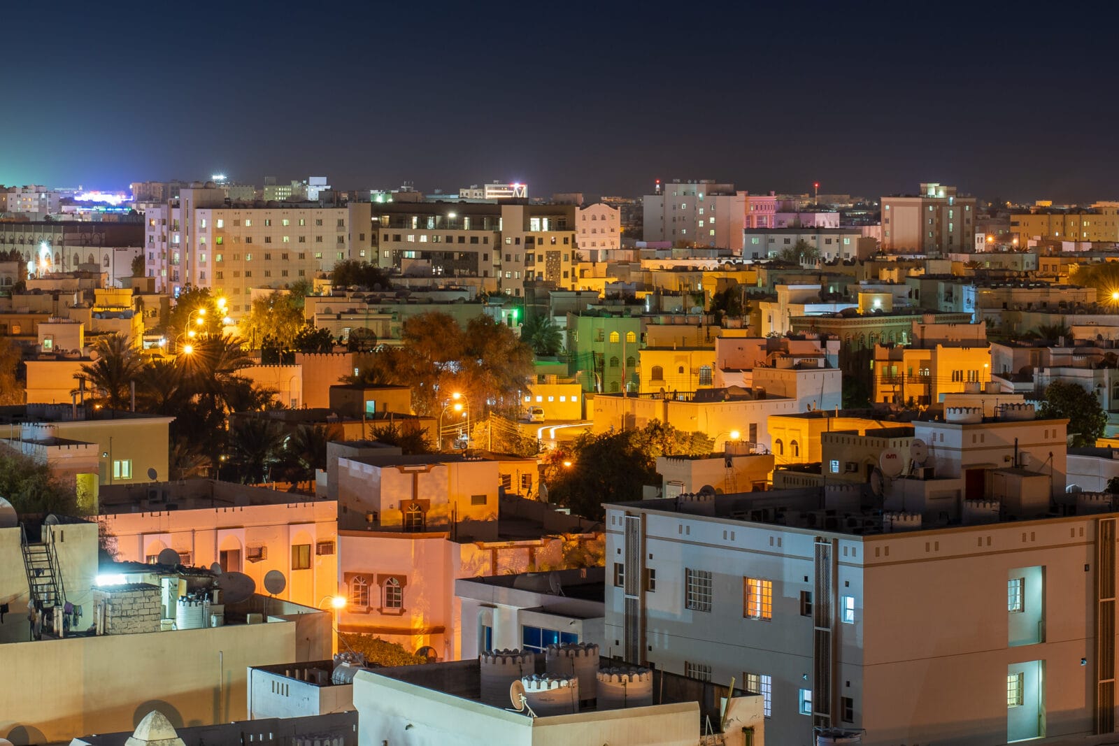 Verlichte gebouwen bij nacht in Muscat