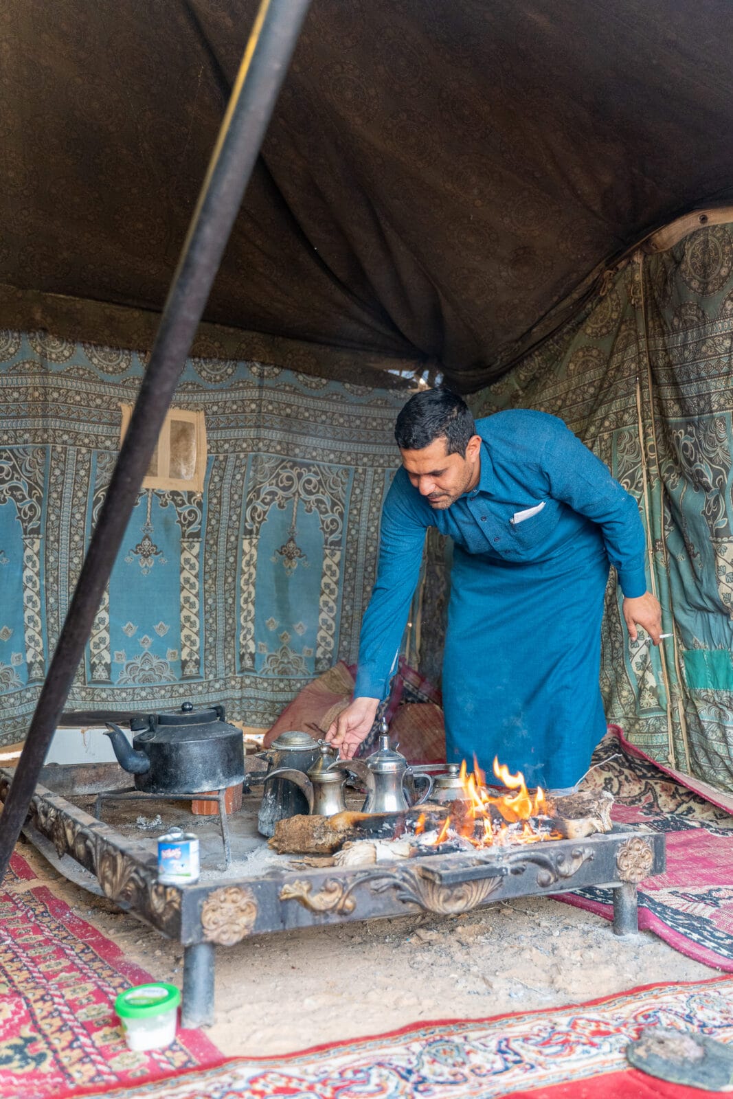 Man zet koffie op een open vuur in de tent bij Jubbah