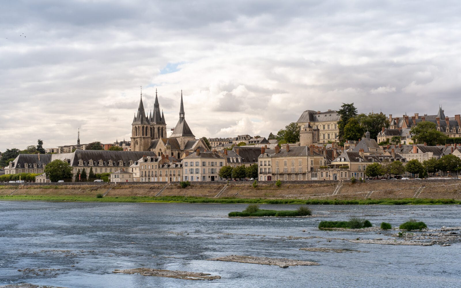 De Loireoever en de skyline van Blois onder een wolkenlucht