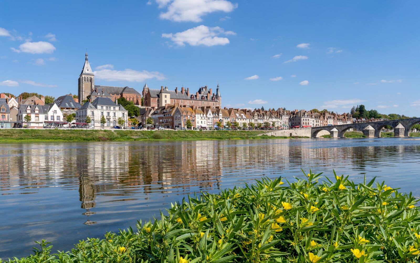 Gien weerspiegeld in de Loire op een zonnige dag