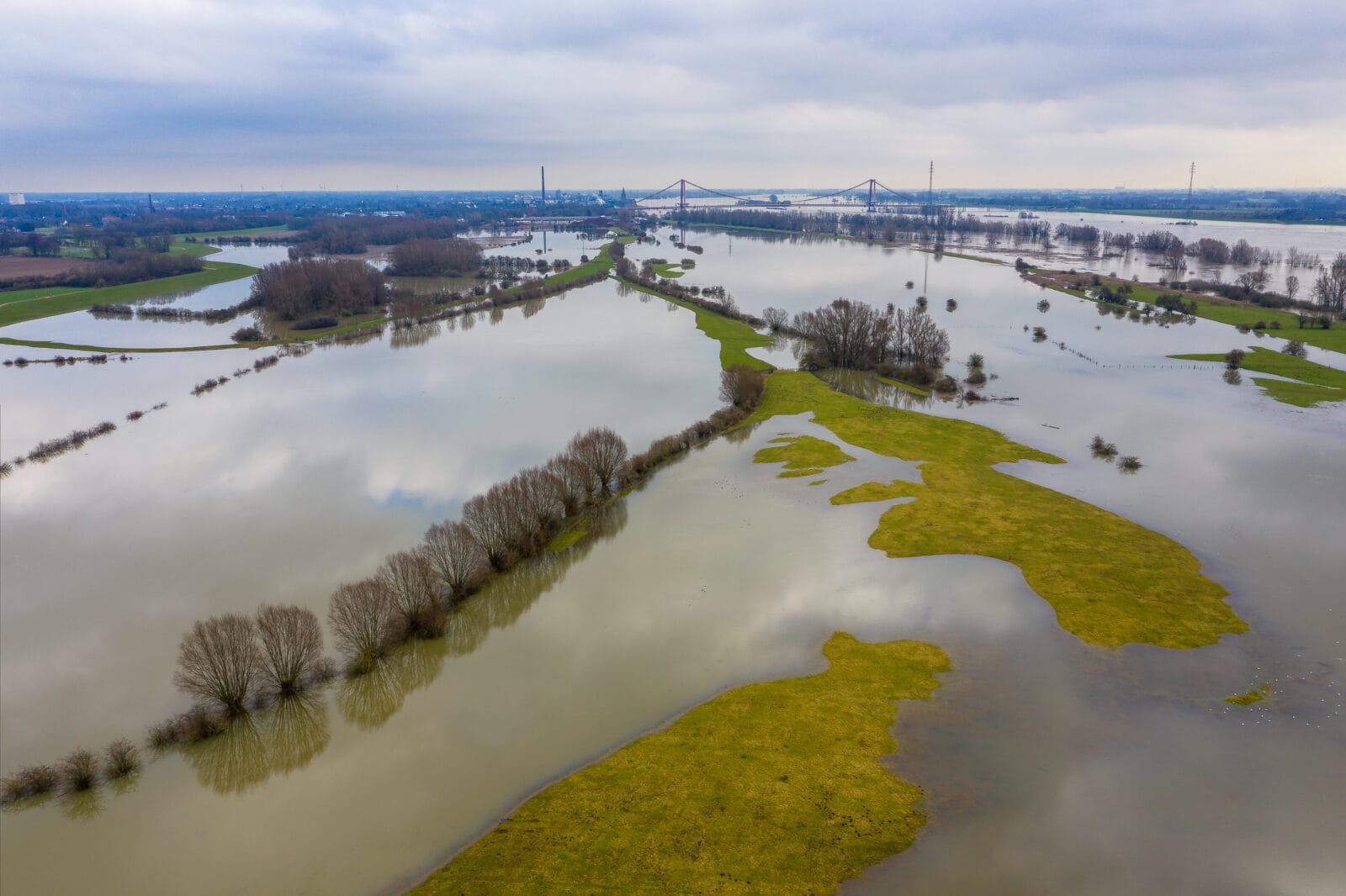 Ondergelopen weilanden bij Hüthum onder een grijze hemel, van boven