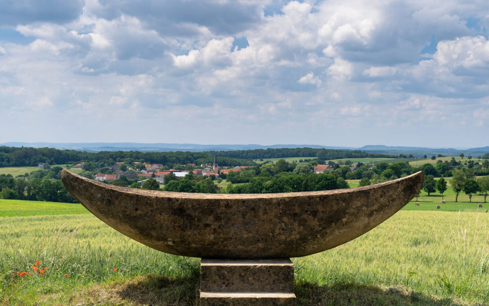 Stenen beeld met uitzicht over een dorp en de heuvels van het Saarland
