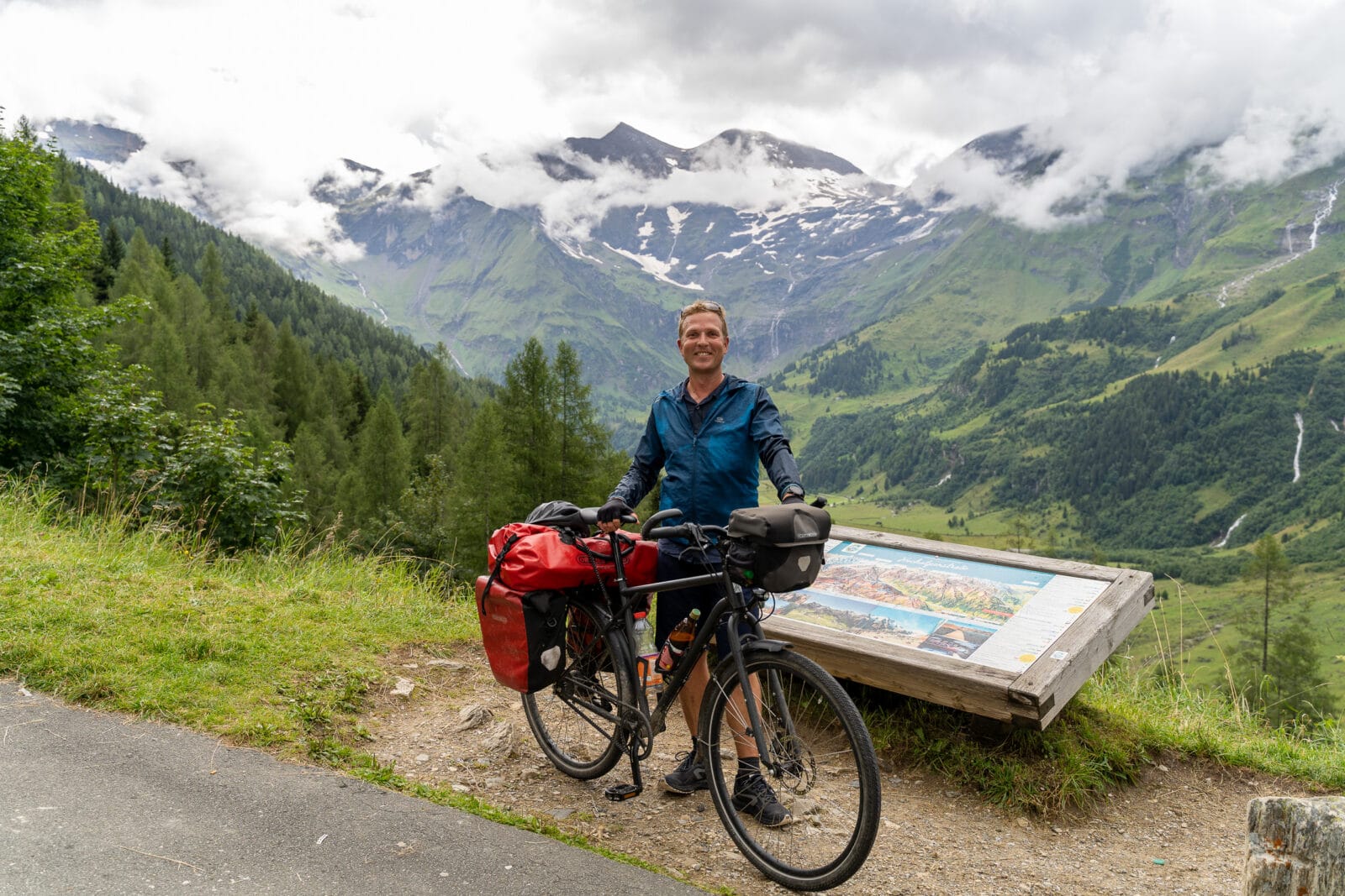 Fietser bij zijn bepakte fiets aan de Großglockner Hochalpenstraße boven Fusch