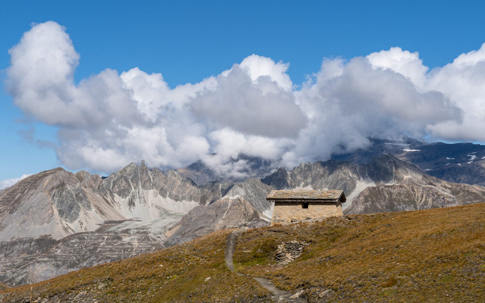 Stenen hut tegen de bergwand bij de Col de l'Iseran