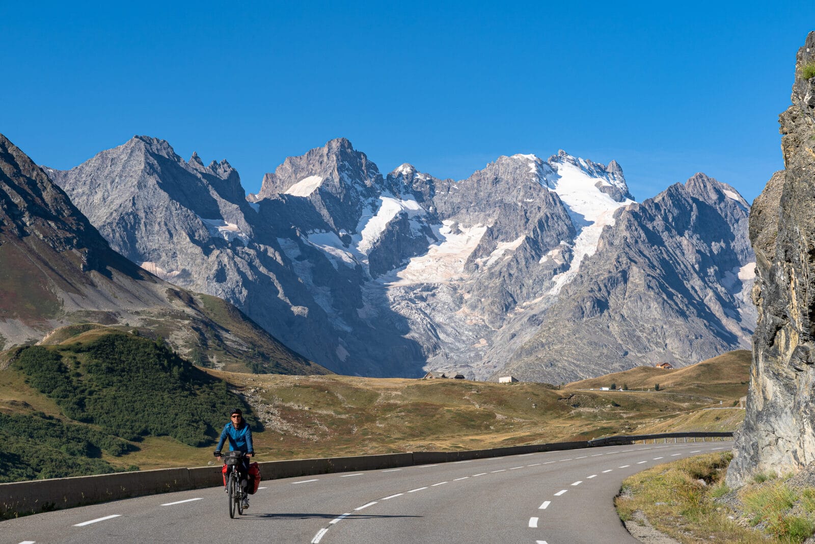 Fietser op weg naar de besneeuwde toppen bij de Col du Lautaret
