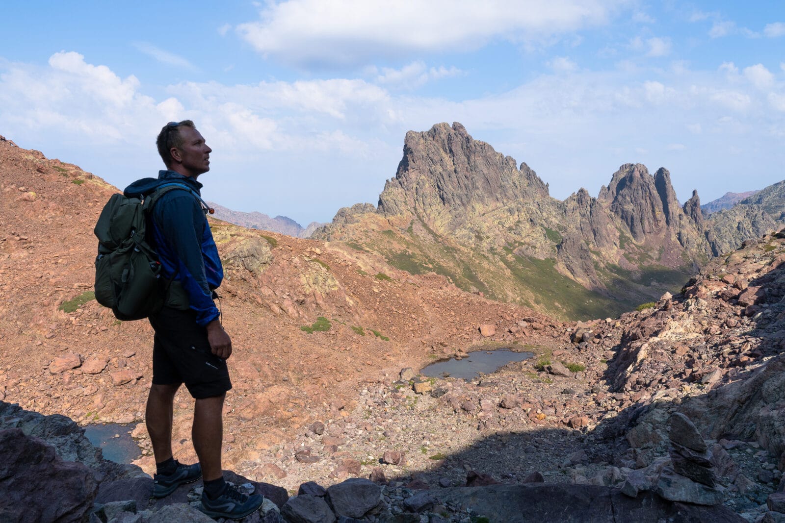 Wandelaar kijkt uit over de ruige toppen bij Asco, Corsica