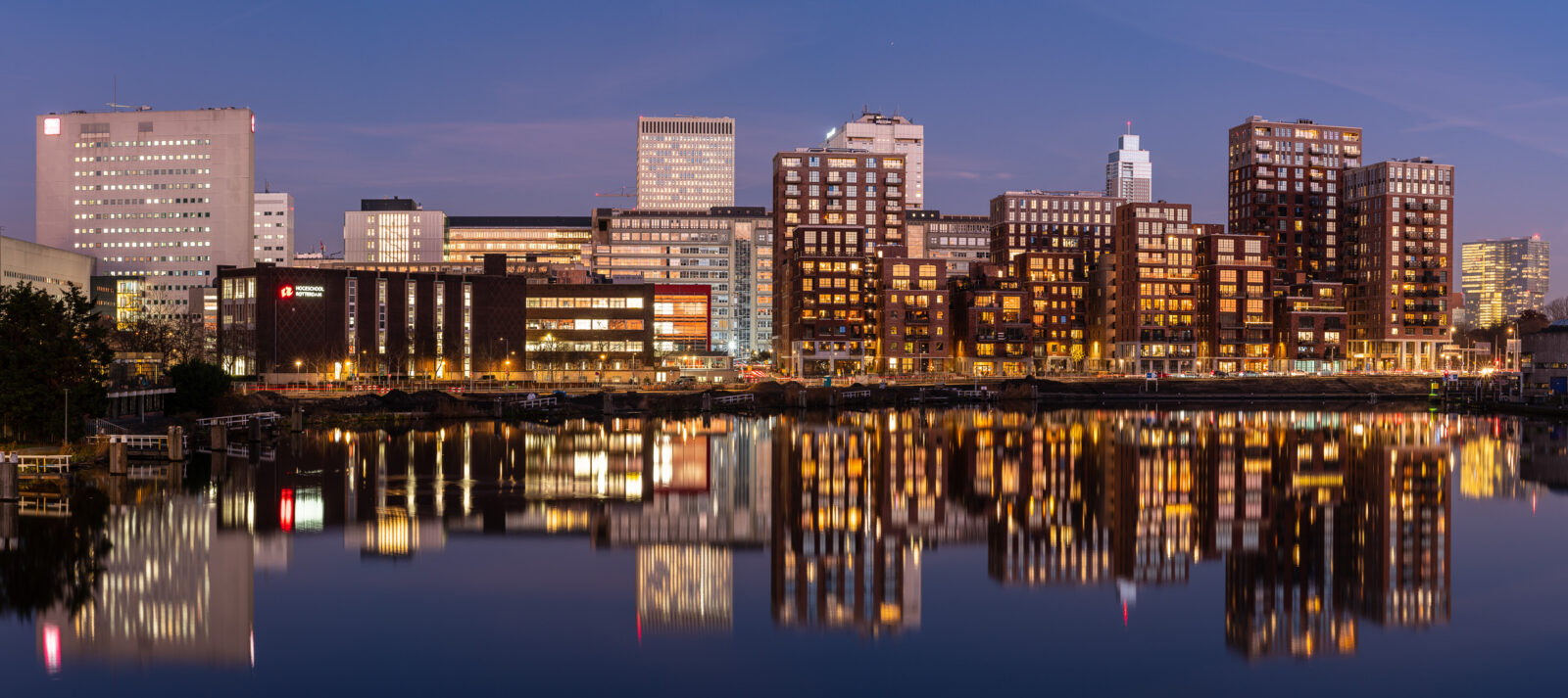Panorama van de Rotterdamse skyline bij avond