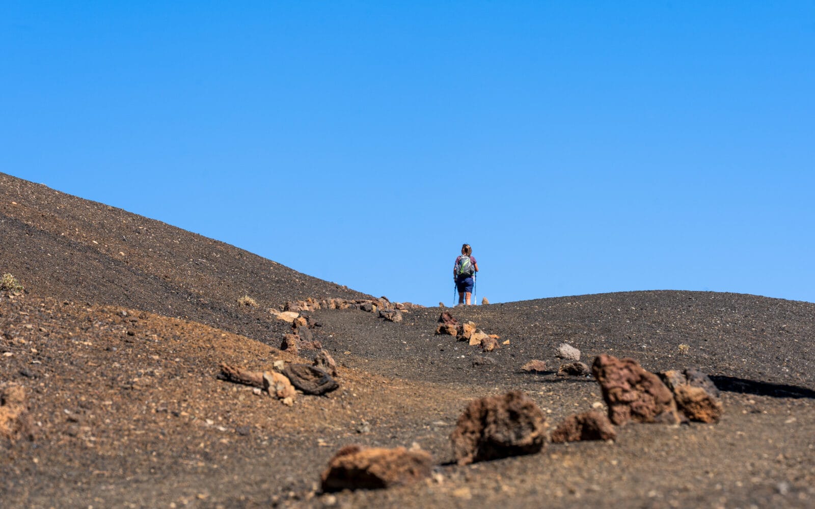 Wandelaar klimt door het zwarte zand van Arenas Negras op Tenerife