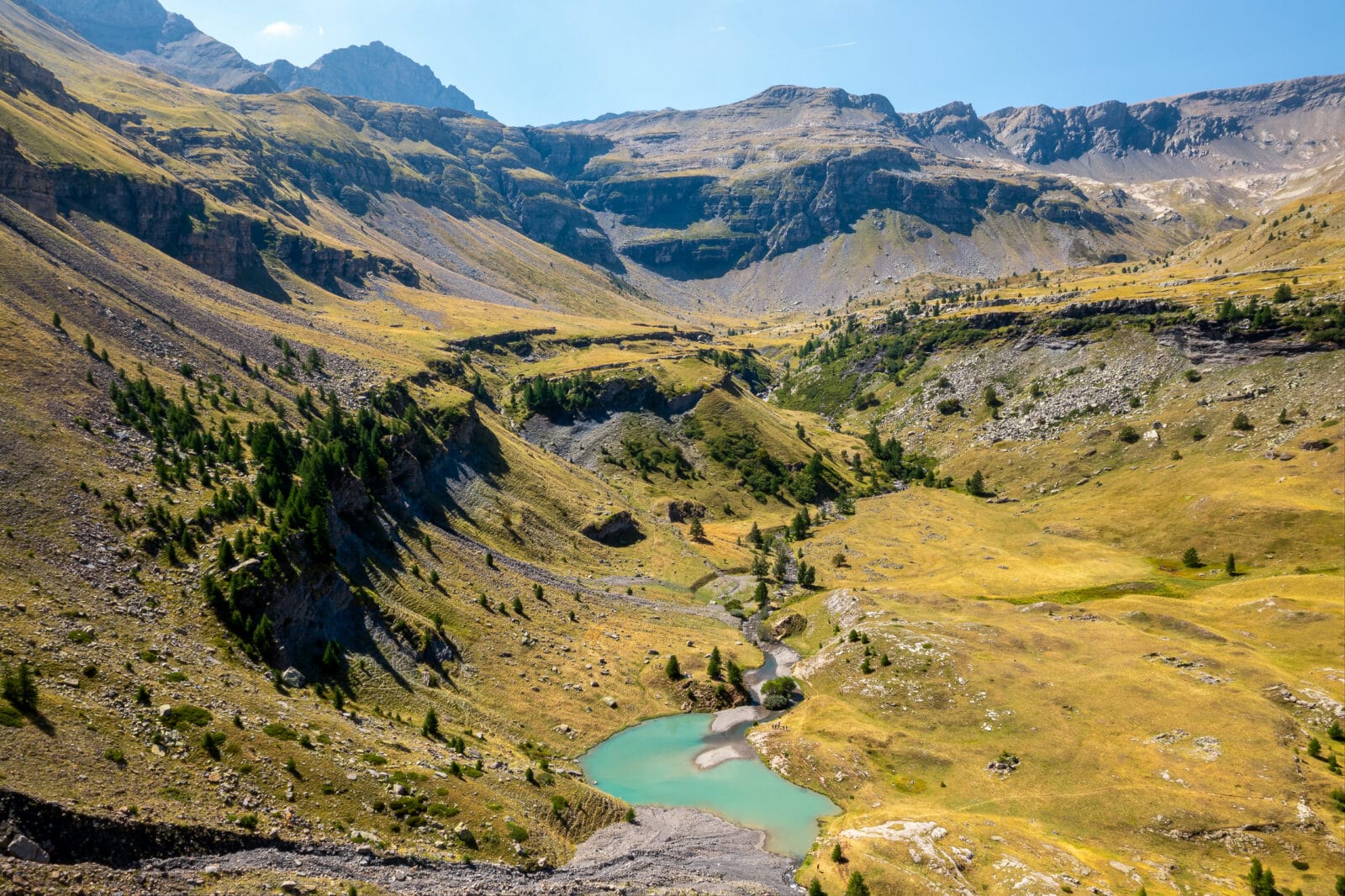 Turquoise bergmeer in een goudgeel dal bij Freissinières, van boven