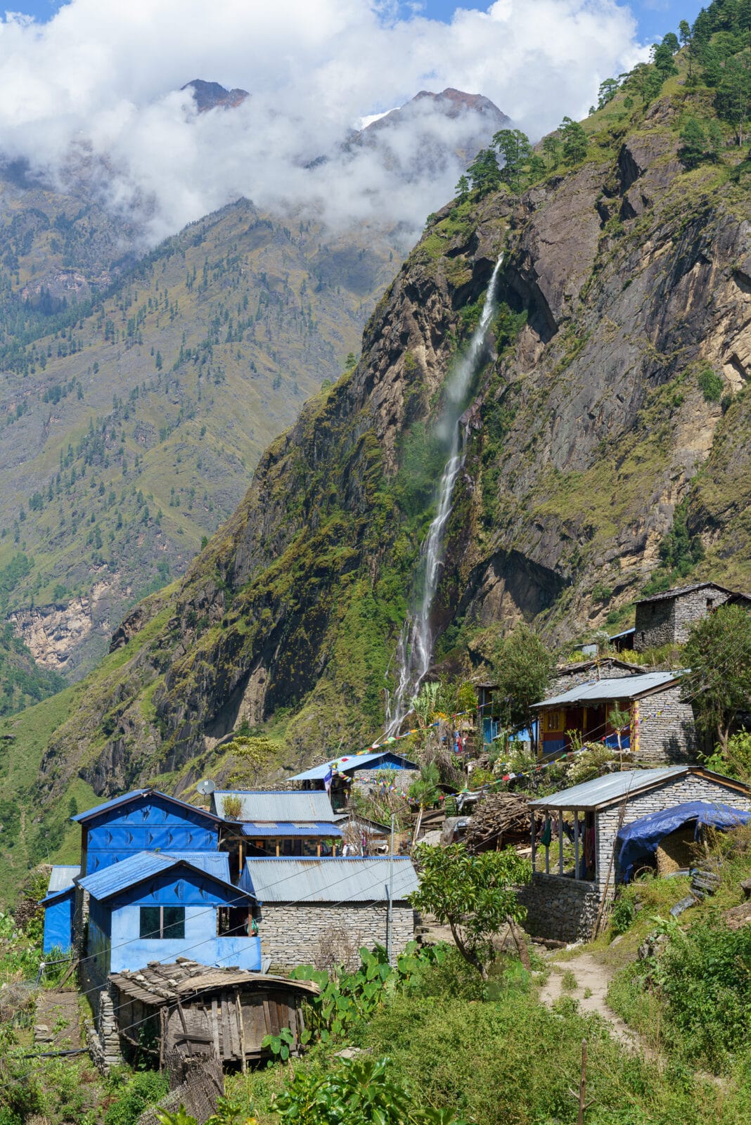 Dorp onder een waterval in de Budhi Gandaki-vallei bij Philim