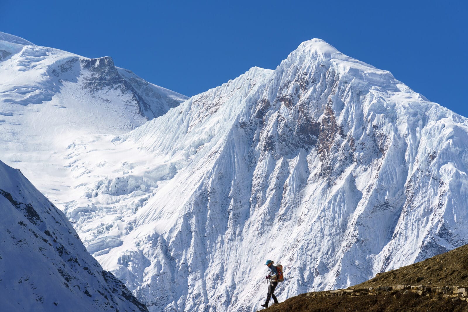 Trekker klimt door de sneeuw richting Dharmasala