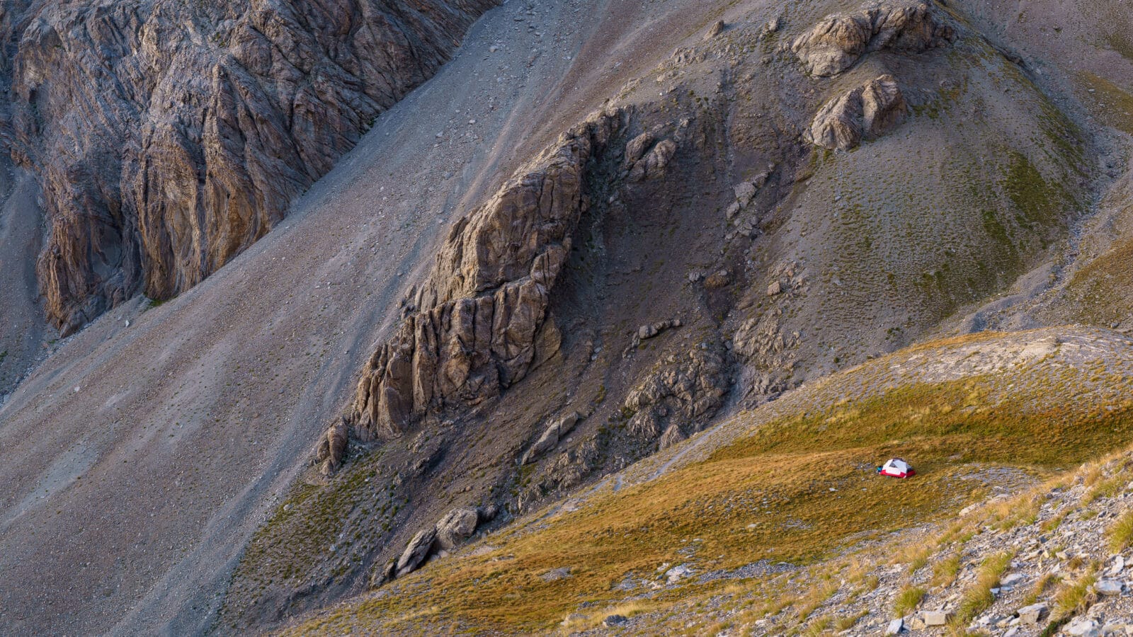 Tentje op een groene richel onder de puinhelling bij de Col de la Cayolle