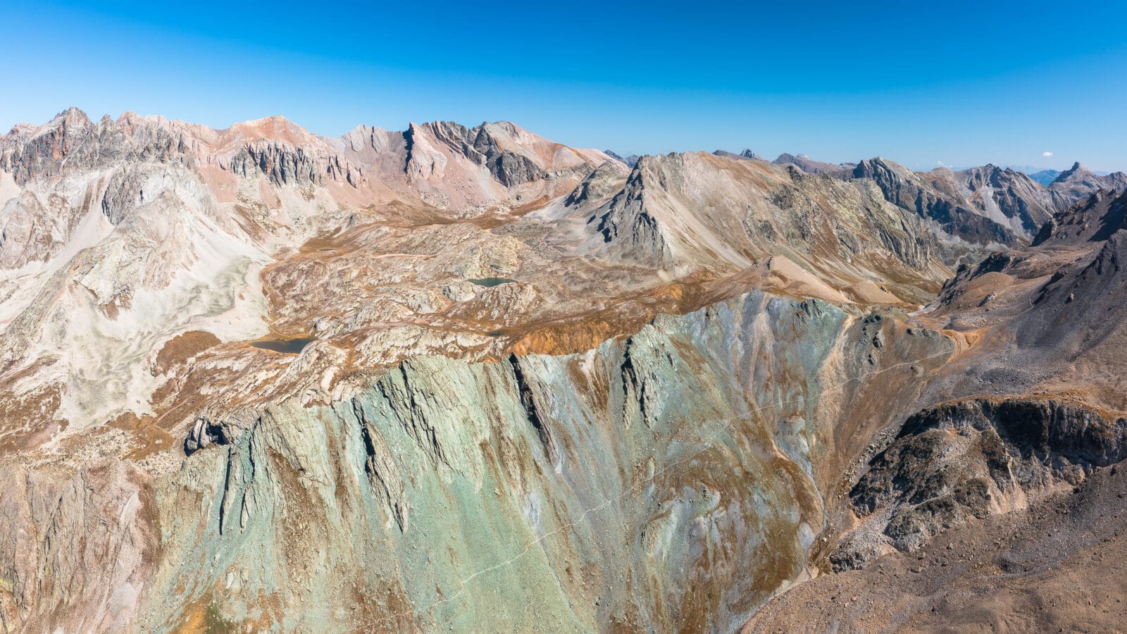 Gekleurde mineraalafzettingen op de berghellingen bij Saint-Paul-sur-Ubaye, van boven