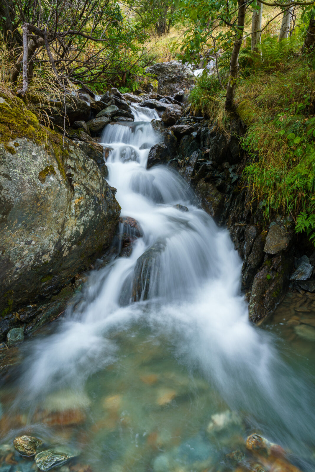 Waterval over bemoste rotsen bij Saint-Christophe-en-Oisans