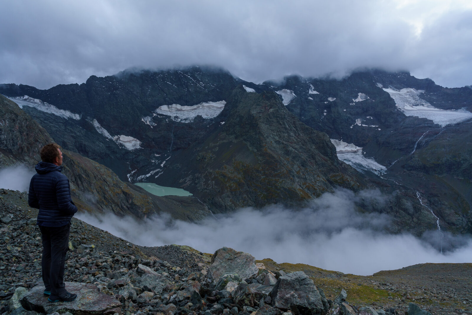 Man kijkt naar de mistige bergen en het gletsjermeer bij Saint-Christophe-en-Oisans