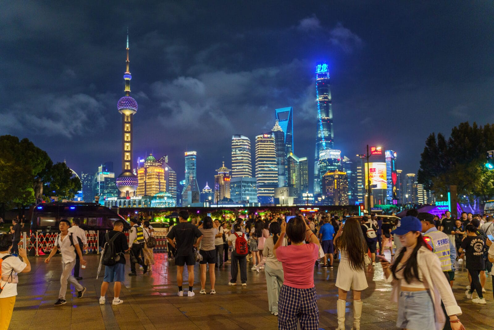 Avondpubliek op de Bund kijkt naar de skyline van Pudong, Shanghai
