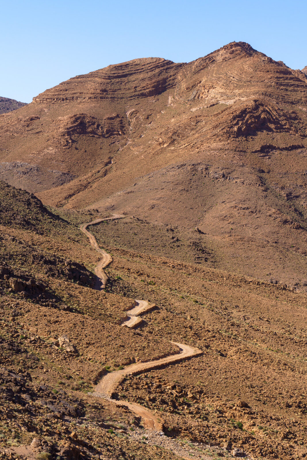 Winding mountain road under a clear blue sky