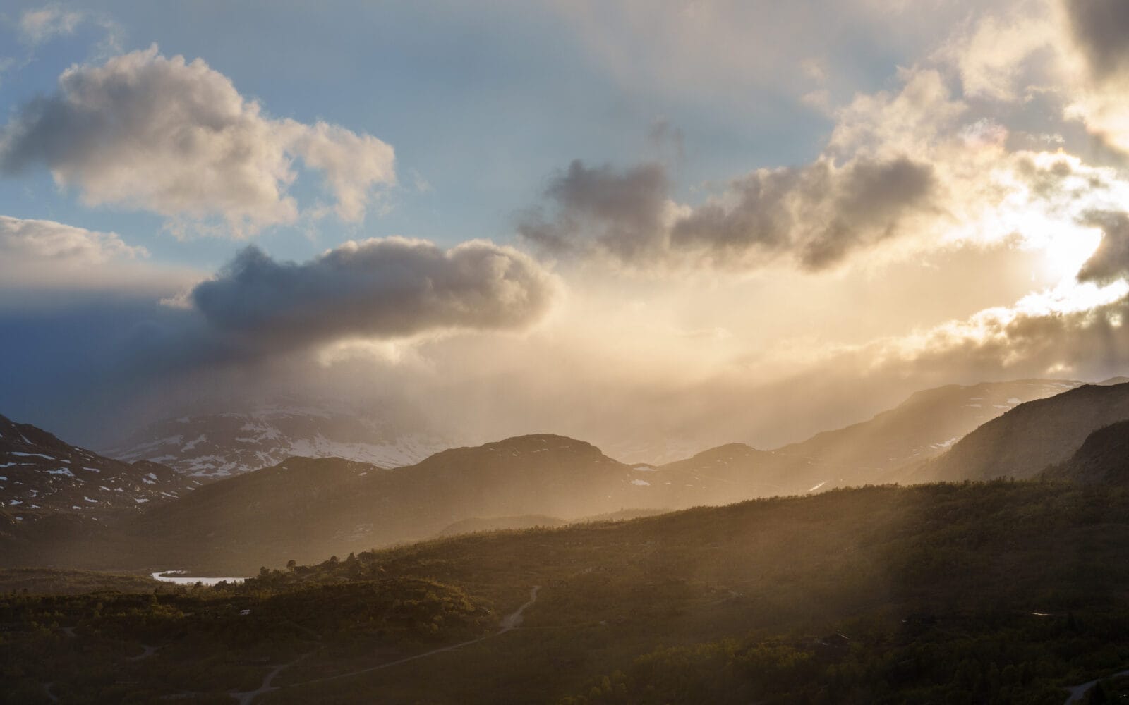 Goudkleurig licht door de wolken boven de bergen bij Vågsli op de Haukelifjell