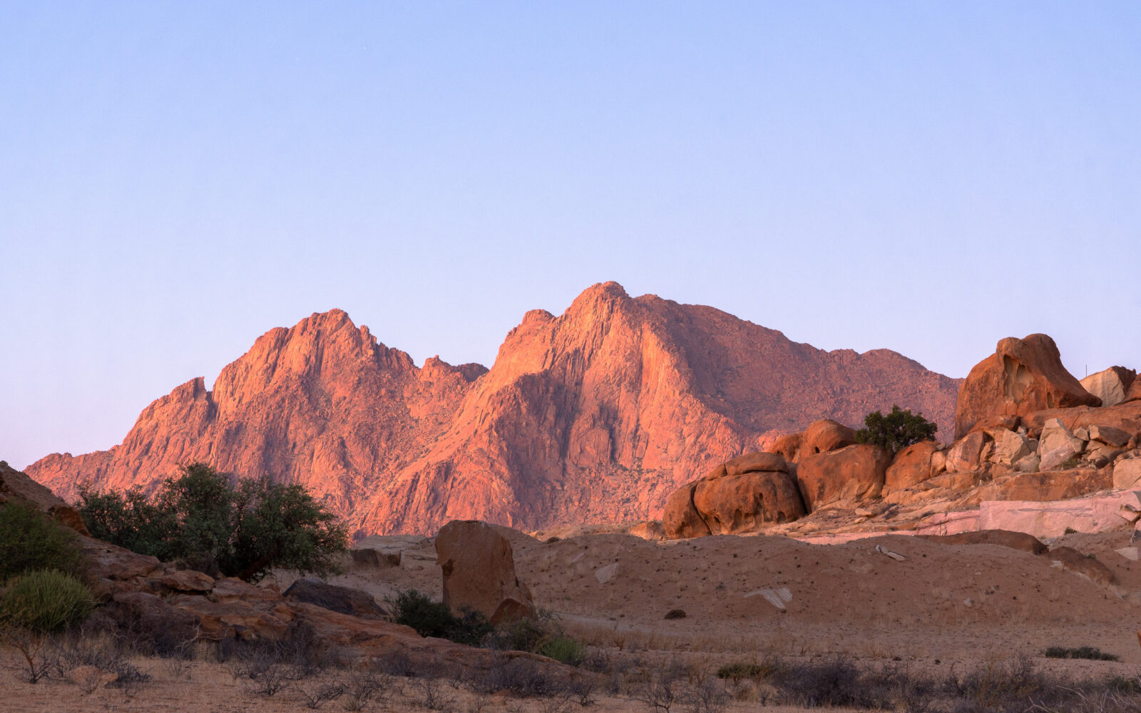 Twilight paints the desert mountains red
