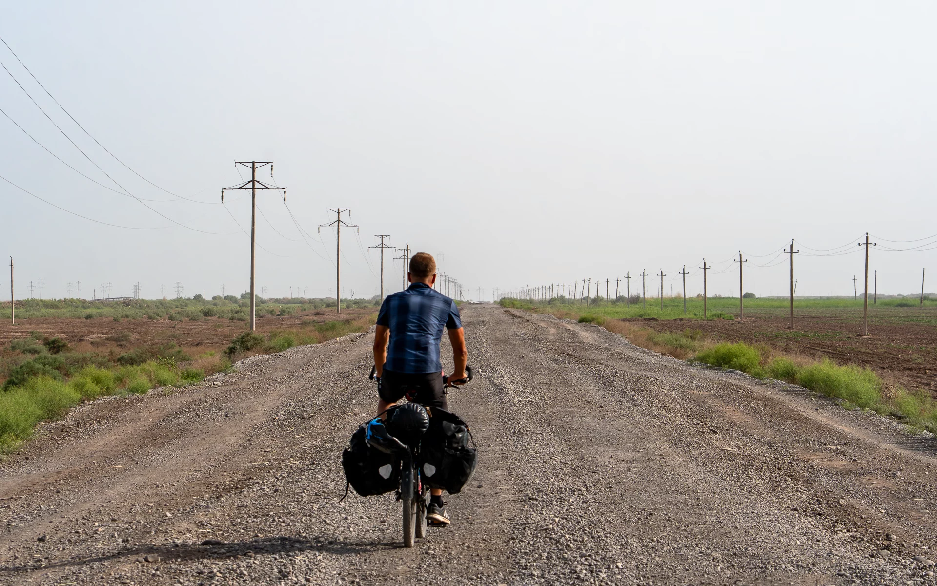 Bepakte reisfiets op een opgebroken grindweg tussen Sarakhs en Mary in Turkmenistan