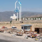 Wit provinciemonument met de Oezbeekse vlag en kraampjes langs de Takhtakaracha-pas
