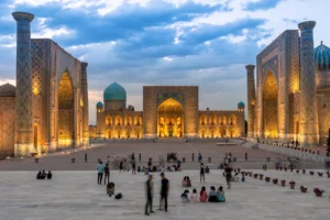 Het uitgelichte Registan-plein in Samarkand tijdens het blauwe uur, met mensen op het plein